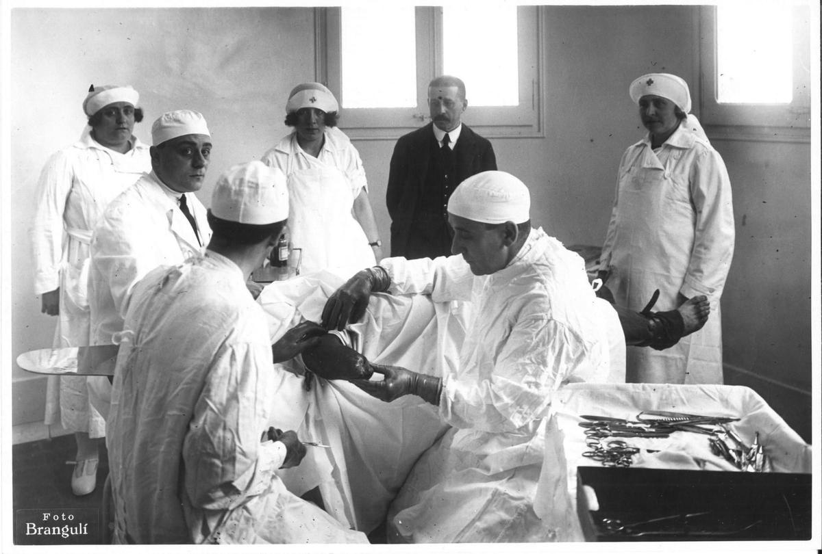 Francesc Moragas (director general de la Caja de Pensiones para la Vejez y de Ahorros), observando una intervención quirúrgica para la adaptación de una prótesis (1922). Instituto para la rehabilitación física de mutilados.
