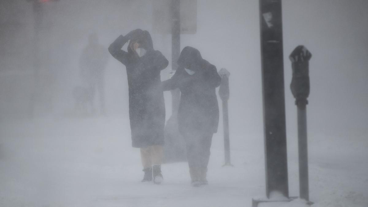 Dos personas tratan de protegerse del temporal de viento y nieve en Boston