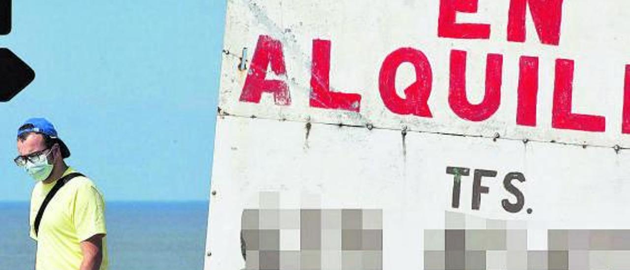 Un hombre pasa al lado de un gran cartel que anuncia viviendas en alquiler en el sur de Tenerife. | |