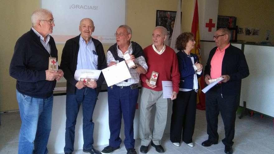 Socios de Cruz Roja, que ayer recibieron el homenaje, muestran el diploma y el obsequio.