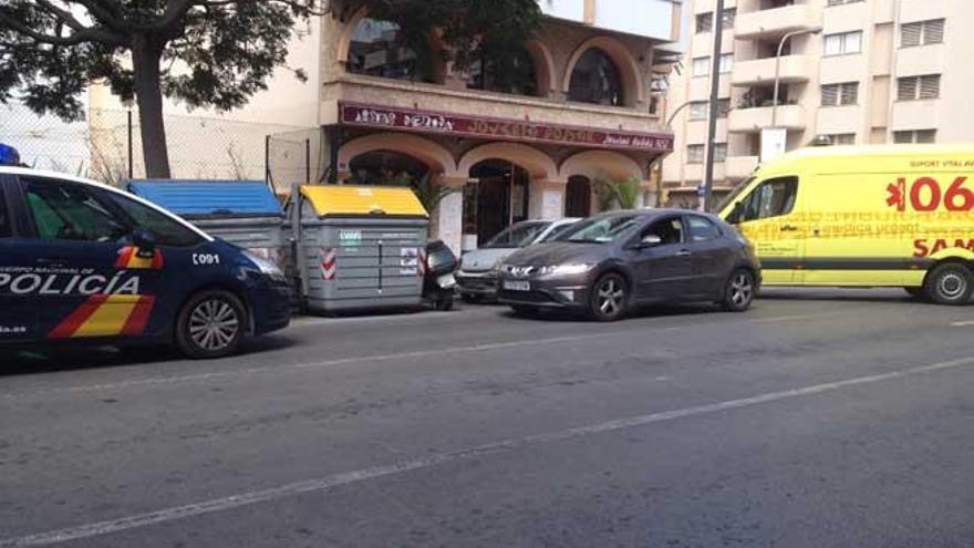 La moto del herido, apoyada en los contenedores, y el coche con el que colisionó.