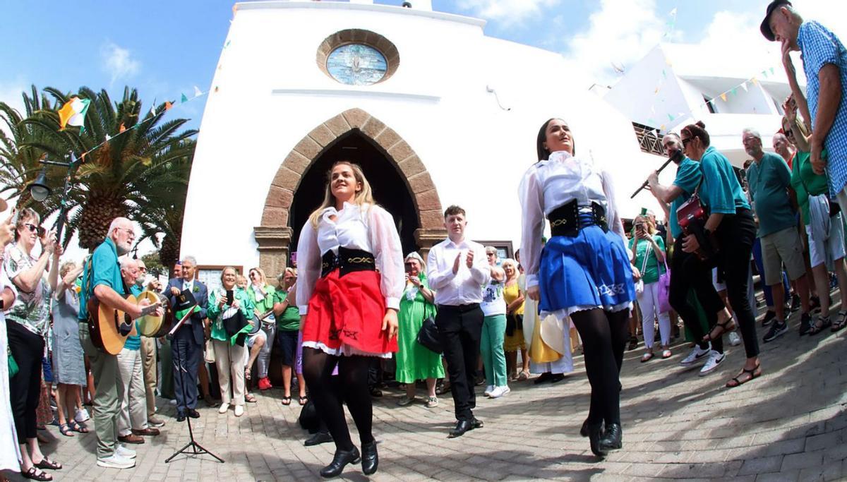 Dos chicas bailan con vestimenta irlandesa, a la salida de la iglesia. | | PRENSA TÍAS