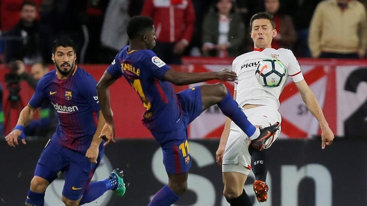 Dembelé y Lenglet pugnan por un balón ante la mirada de Suárez.