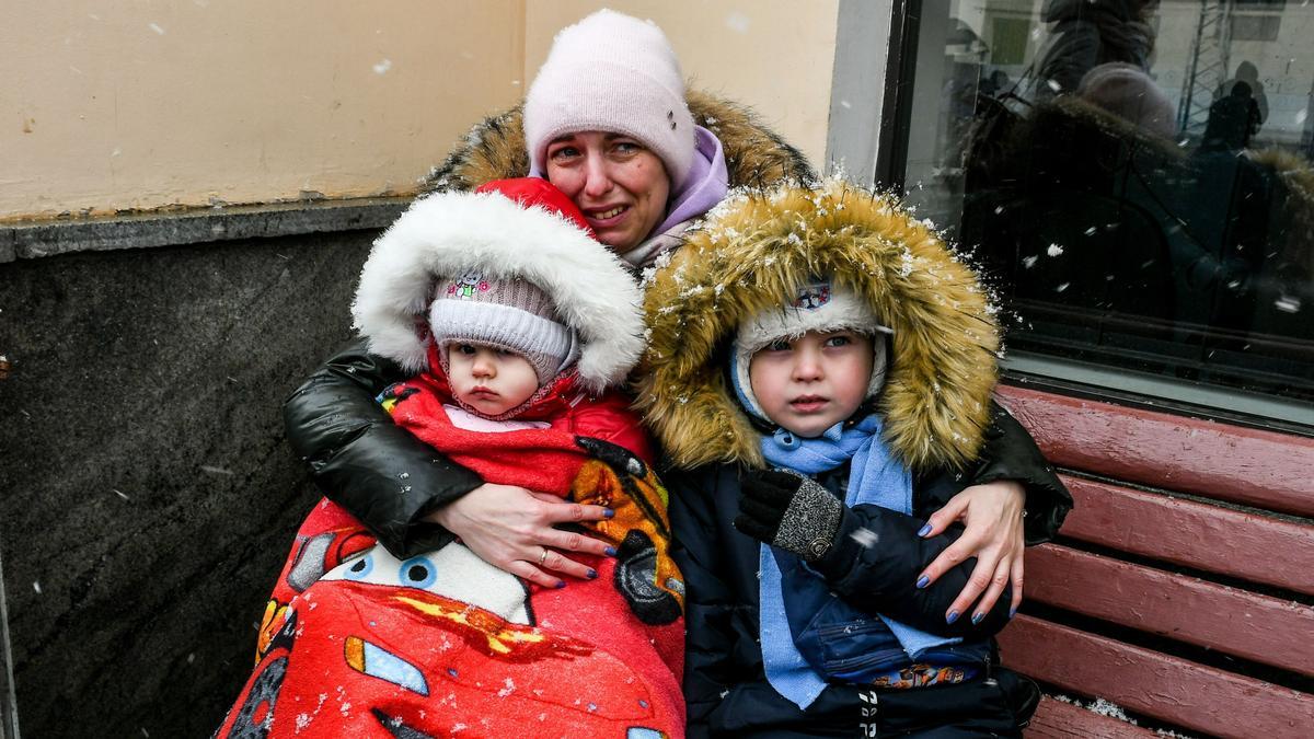 Una mujer y sus dos hijos esperan un tren de evacuación en Zaporizhzhia en medio de las operaciones militares rusas en Ucrania.