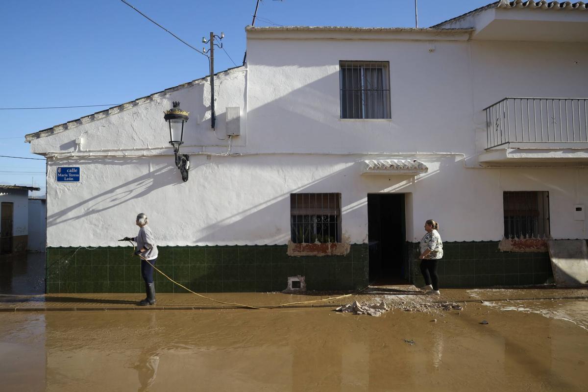 Los vecinos de la barriada de Doña Ana en la Estación de Cártama, junto al operarios Infoca, limpian los estragos de la nueva inundación provocada por la crecida del Guadalhorce durante la borrasca Francis