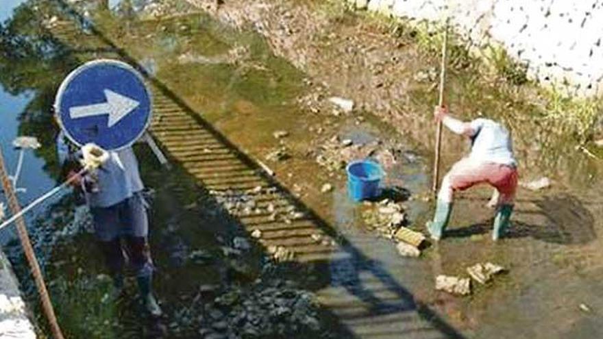 Los turistas, en plena limpieza del cauce del torrente.