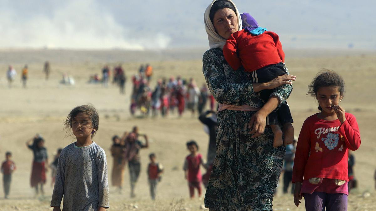 Una mujer yazidí con dos niñas huyen del Estado Islámico.