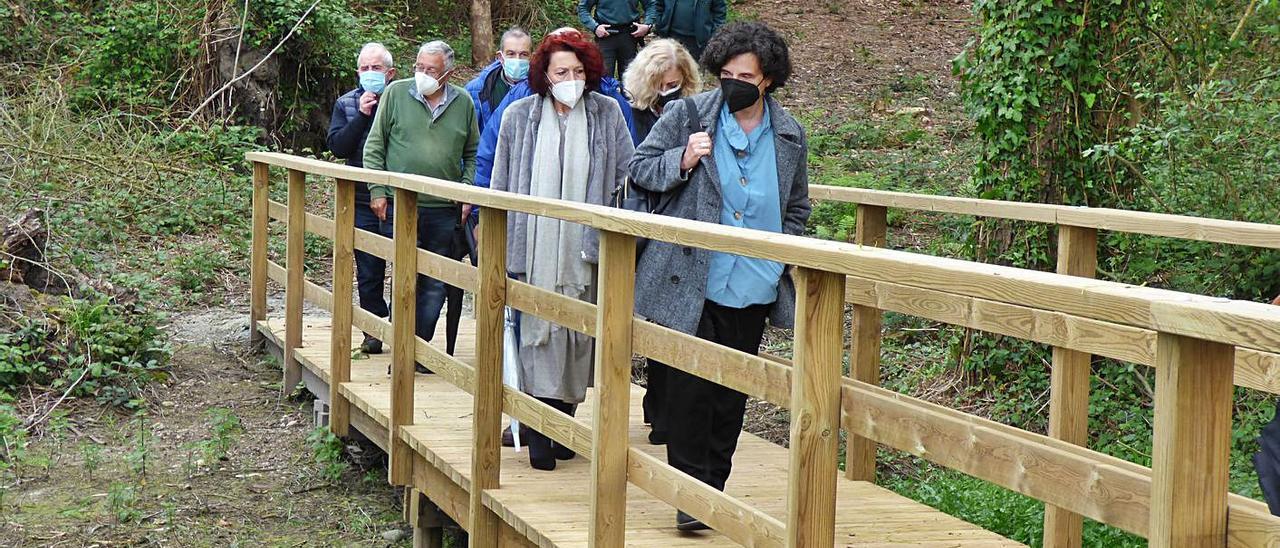 La consejera Berta Piñán, seguida por la alcaldesa Cecilia Pérez, la edil Victoria Zarcero y miembros de la Asociación Astur-Galaica de Amigos del Camino de Santiago de la Costa, ayer, cruzando la nueva pasarela. | D. Á.