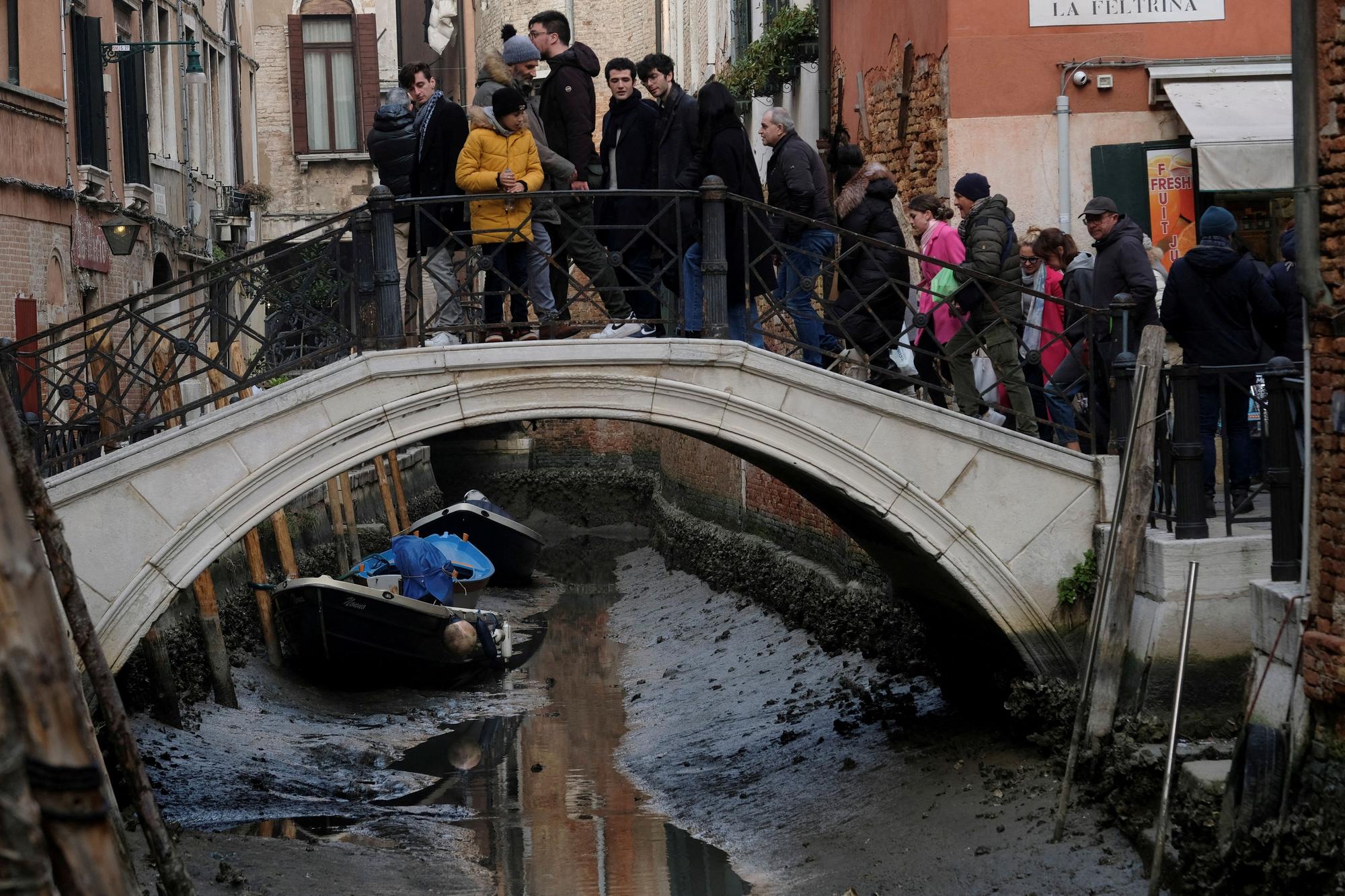 Boats are pictured in a canal during a severe low tide in the lagoon city of Venice