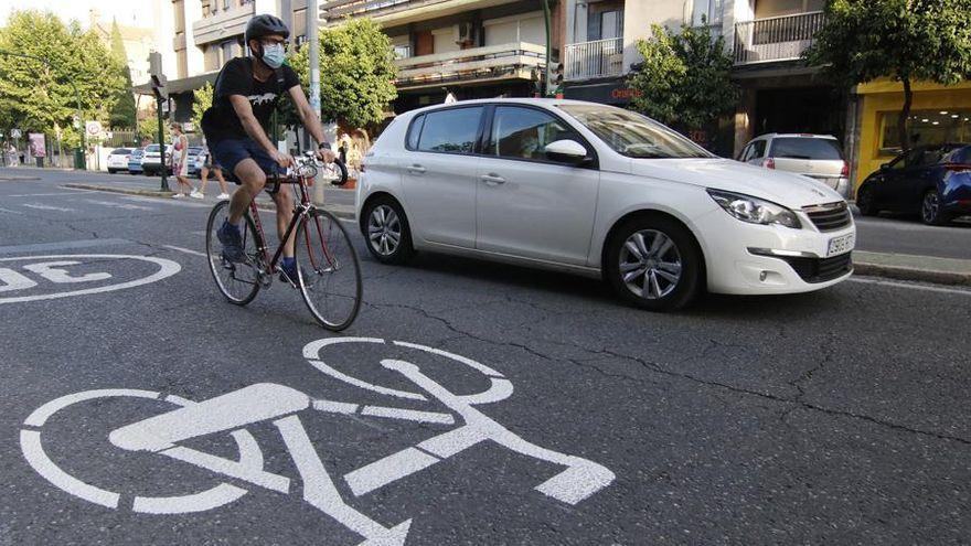 Un ciclista y un vehículo circulan por una ciclocalle de Córdoba.
