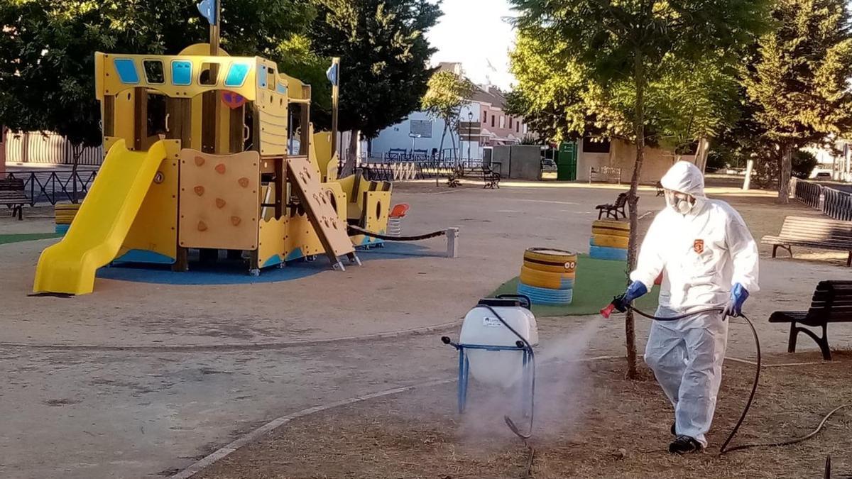 Un hombre fumiga un parque infantil para luchar contra el mosquito.