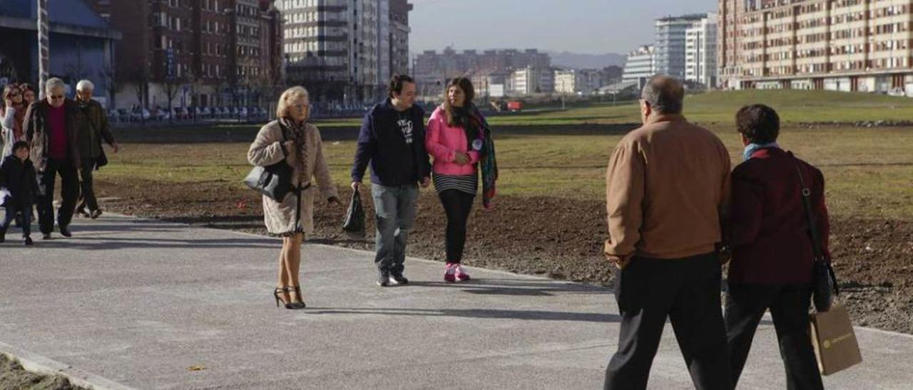 Peatones cruzan por uno de los pasos de peatones habilitados en el solar liberado de las vías.