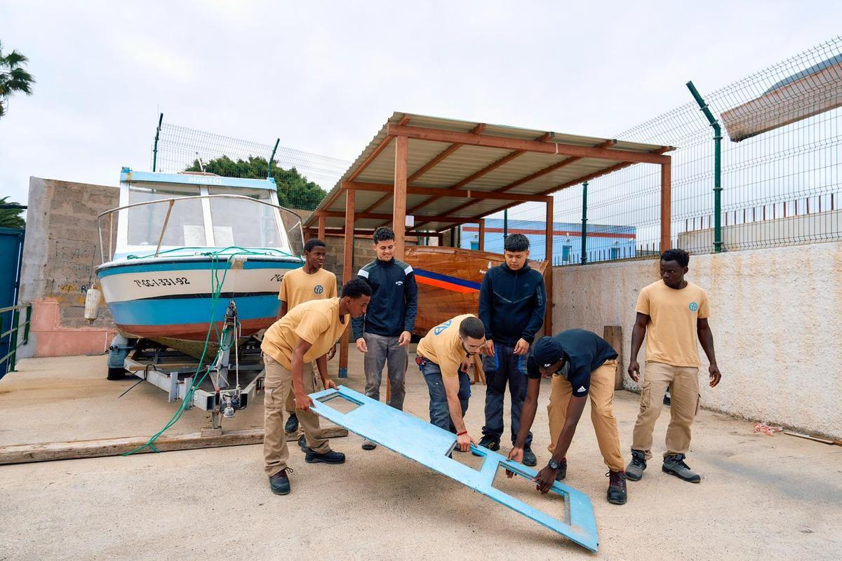 Varios alumnos desmontan parte de la embarcación que se convertirá en convertirá en una lancha ambulancia.