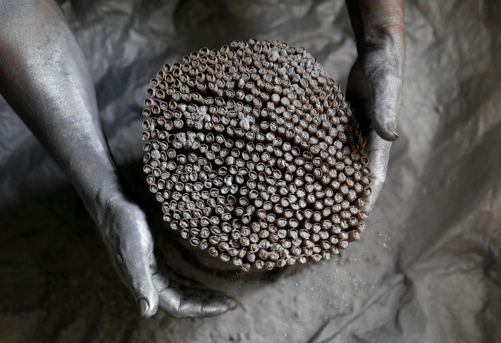 A worker covers firecrackers with gunpowder in a ...