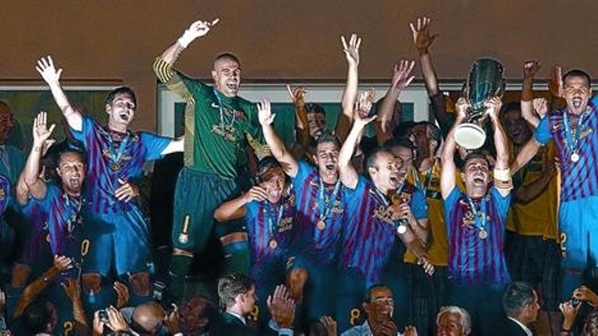 Xavi alza el trofeo de la Supercopa rodeado por sus compañeros en el palco del estadio Luis II de Mónaco, ayer.