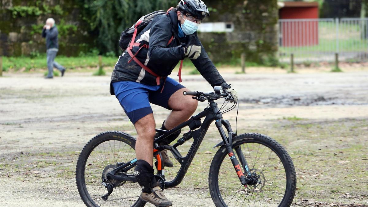 Un hombre, en bicicleta por el Parque de Castrelos en Vigo.