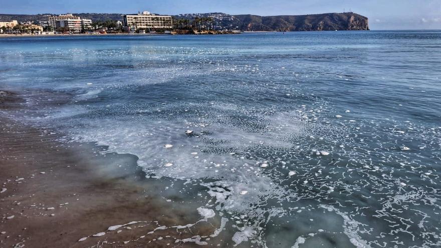 No es un vertido: la playa del Arenal, la más turística de Xàbia, amanece con espuma y una gran mancha blanca