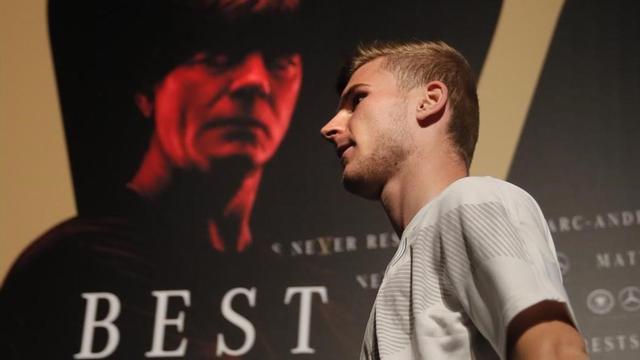 Timo Werner pasa por delante del póster que ilustra Joachim Löw en la concentración de Alemania.