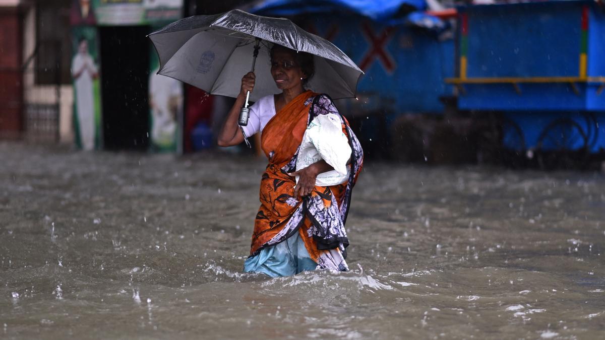 Una mujer camina por una carretera inundada durante las fuertes lluvias, ya que se espera que el ciclón Michaug toque tierra en la costa oriental de la India, en Chennai, India.