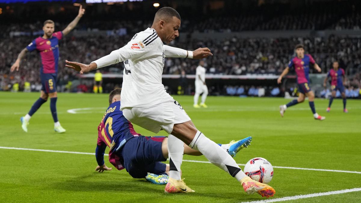 Mbappé intenta el centro ante Casadó en el Madrid-Barça del Bernabéu.