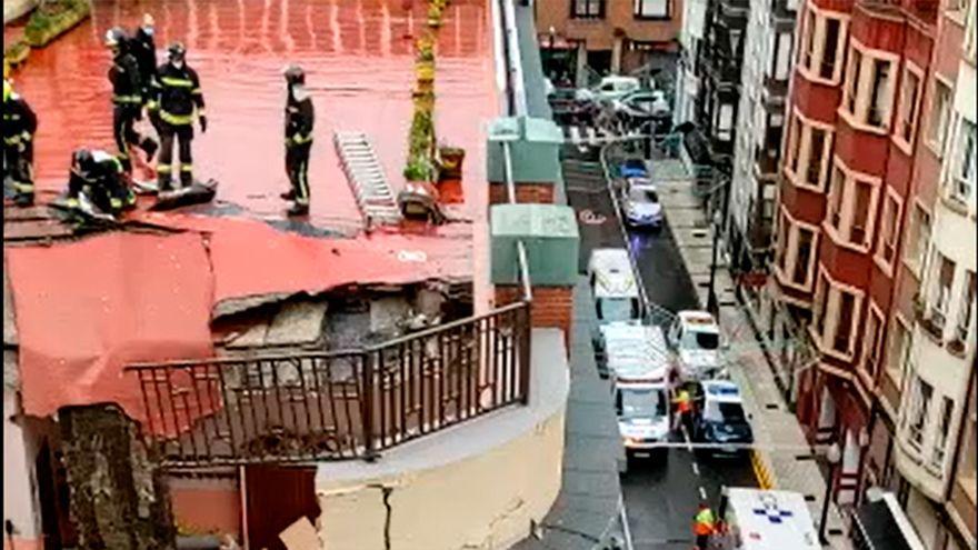 Los bomberos rescatan a un herido del colegio de Gijón tras derrumbarse el tejado.