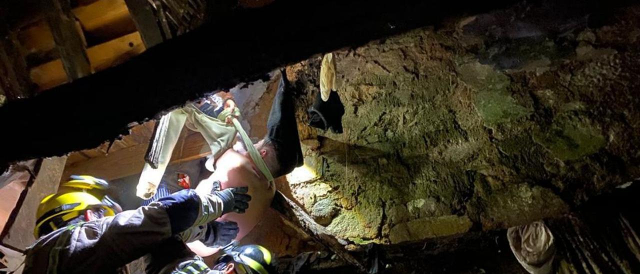 Bomberos, durante la operación de rescate del joven atrapado en las vigas de la casa en ruinas. |  // FDV