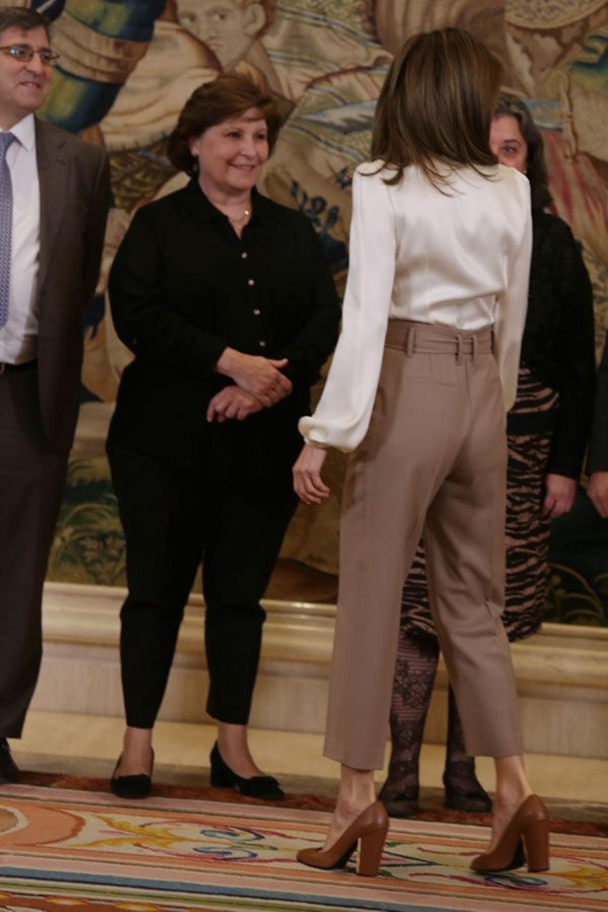 Letizia Ortiz con pantalón beige con lazada, blusa blanca y zapatos marrones de piel