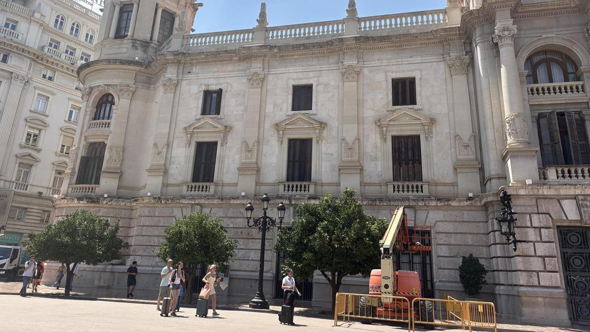 Una màquina treballa en la pintura de les finestres exteriors de l'Ajuntament de València.