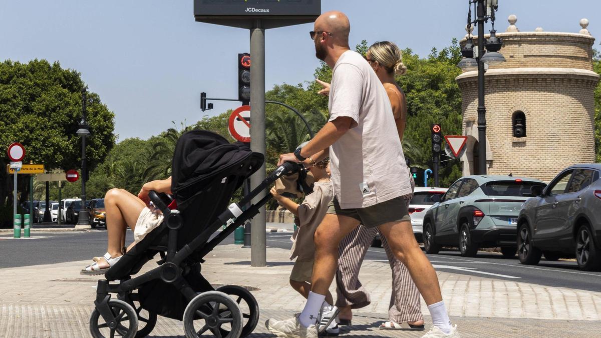 Una familia paseando por València este jueves, durante la tercera ola de calor del verano.