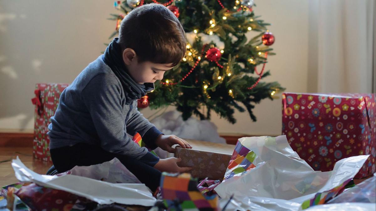 Un niño abre los regalos de Reyes en un hogar español.