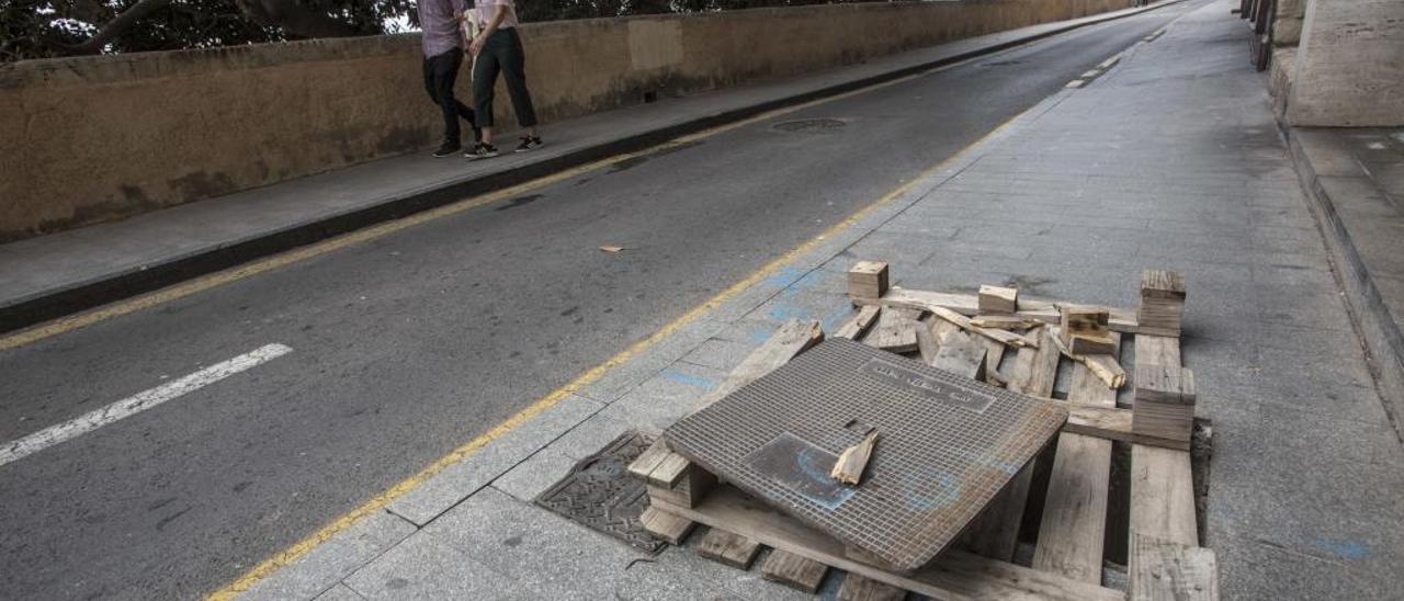 Acera de la calle Virgen del Socorro en la que la tapa del alcantarillado está cubierta con un palé.