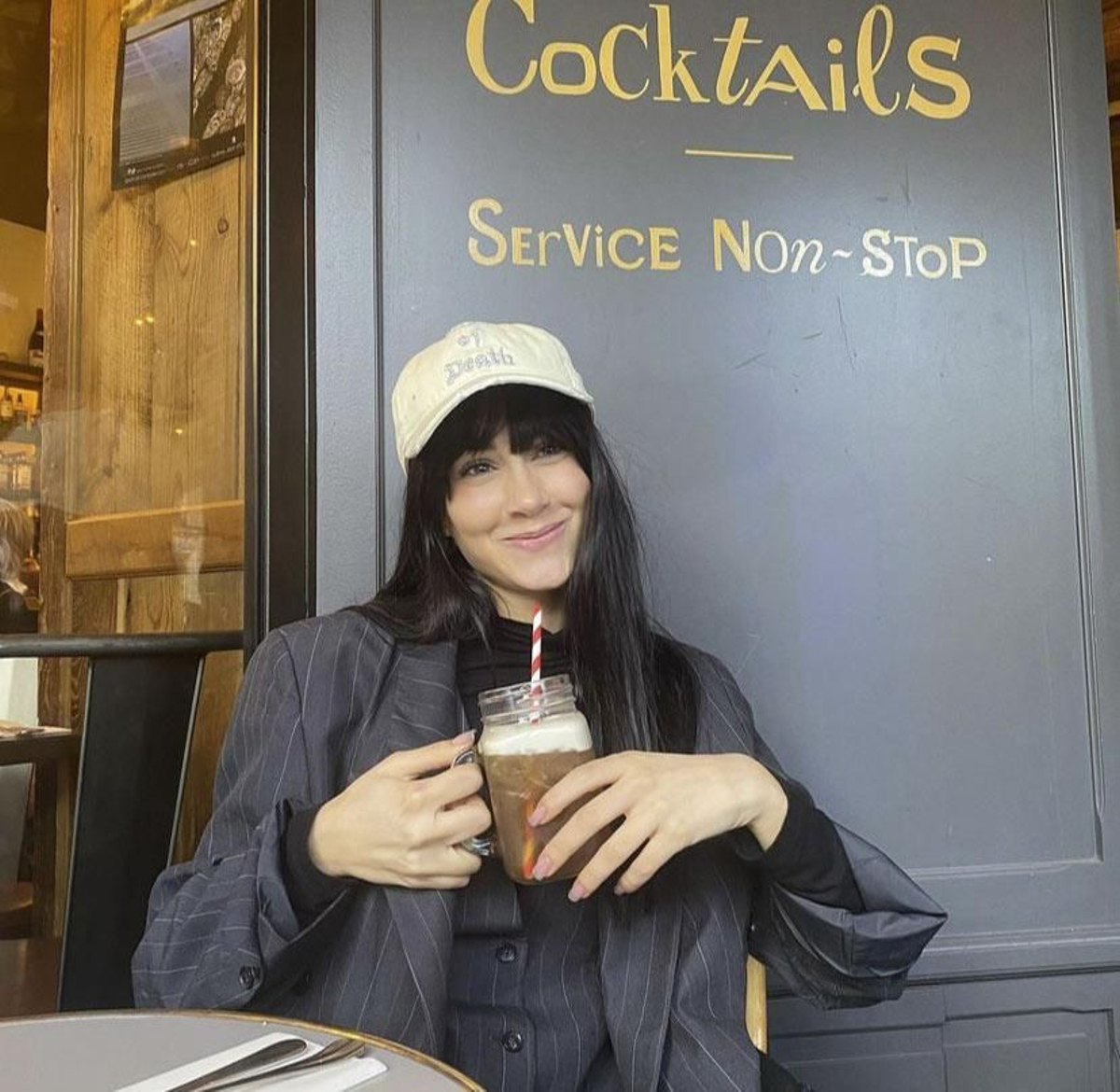Aitana con traje de raya diplomática, gorra y chaleco