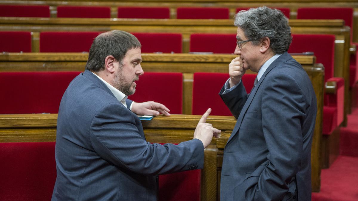 El portavoz del PPC, Enric Millo (derecha), habla con el vicepresidente del Govern, Oriol Junqueras, el pasado marzo en el Parlament.