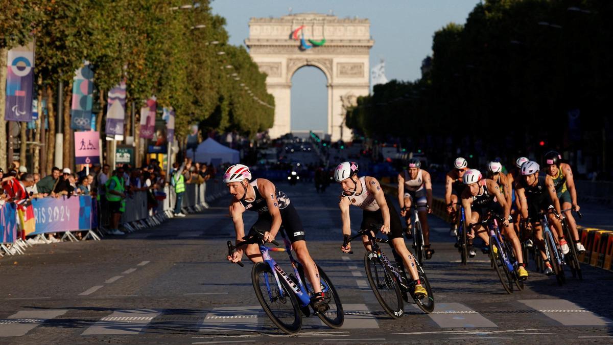 Seth Rider de Estados Unidos seguido por el alemán Tim Hellwig durante la prueba de relevos mixtos de triatlón por el centro de Paris