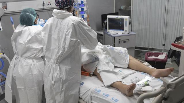 Archivo - Dos sanitarios atienden a un paciente Covid