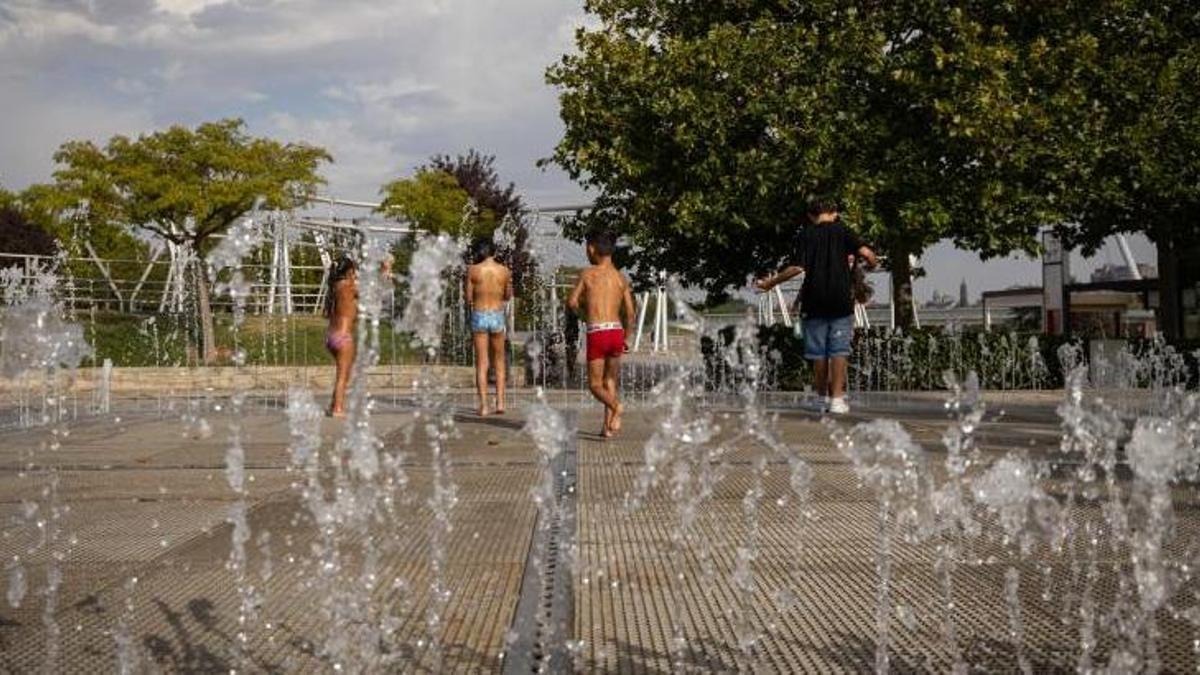 Varios niños se refrescan, este miércoles, en una fuente de Zaragoza, en la zona de la Expo.