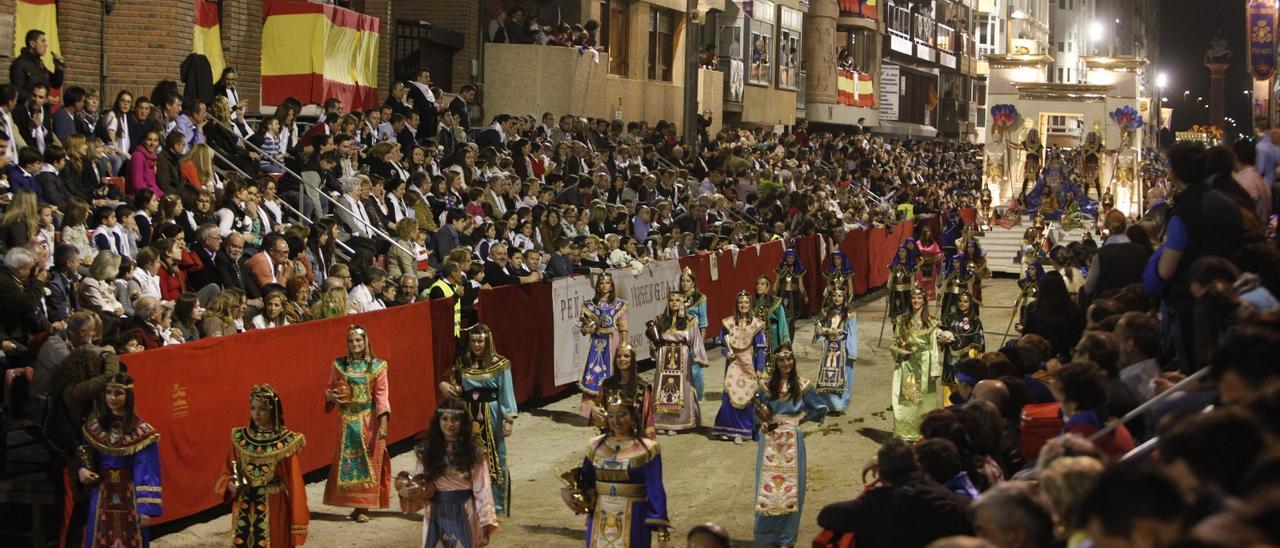 Tribunas de la carrera principal repletas de público que contemplan el paso de la corte de la Reina Meiamen.