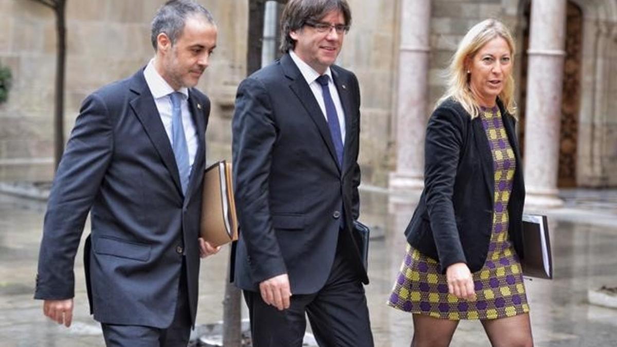 El 'president' Carles Puigdemont, entre la 'consellera' Neus Munté y el secretario del Govern, Joan Vidal, este martes en el Palau de la Generalitat.