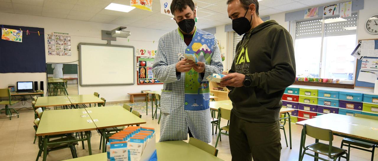 El director del CEIP Froebel y un profesor examinan los test recibido en el centro educativo.