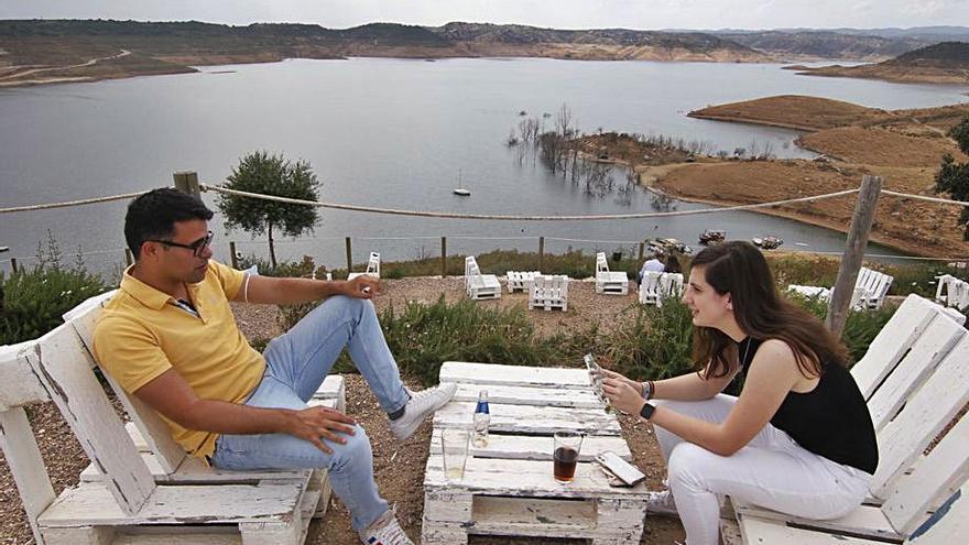 Dos jóvenes conversan en la terraza del chiringuito de La Breña.