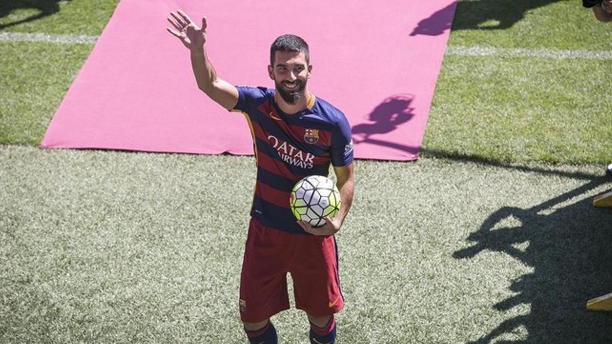 Arda Turan, ya vestido de azulgrana, saluda a los alrededor de 6.000 aficionados del Barça que han acudido a darle la bienvenida al Camp Nou.