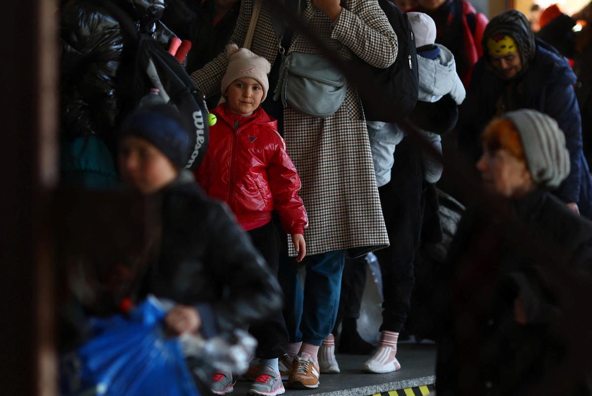 Refugiados ucranianos esperan para pasar por el control fronterizo después de llegar en un tren desde Odesa a la estación de tren de Przemysl Glowny, después de huir de la invasión rusa de Ucrania, en Przemysl, Polonia.