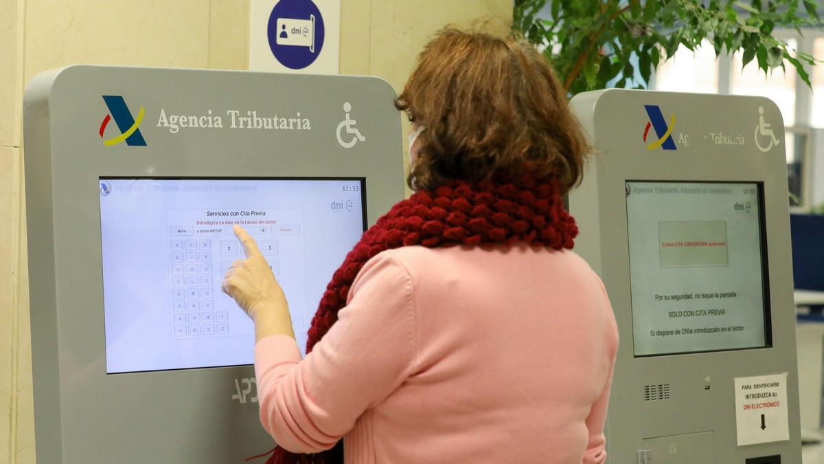 Una mujer recoge su turno en una oficina de la Agencia Tributaria de Madrid.