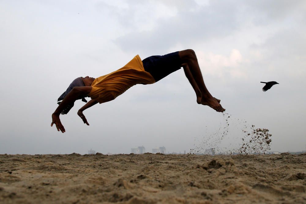 A boy practices somersaulting as he exercises at ...