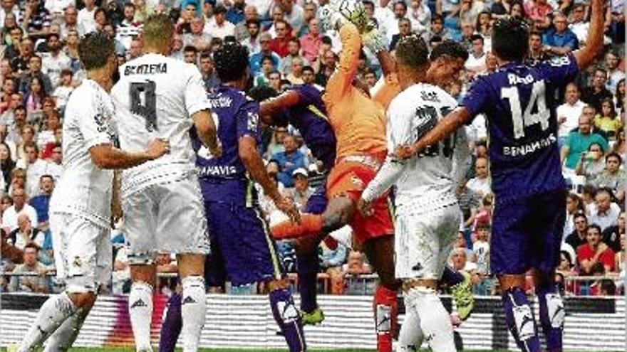 Kameni atrapa una pilota davant la mirada dels davanters del Madrid ahir al Bernabéu.