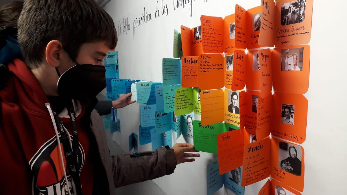 Un niño observa uno de los carteles elaborados en las jornadas de Mujer y Ciencia