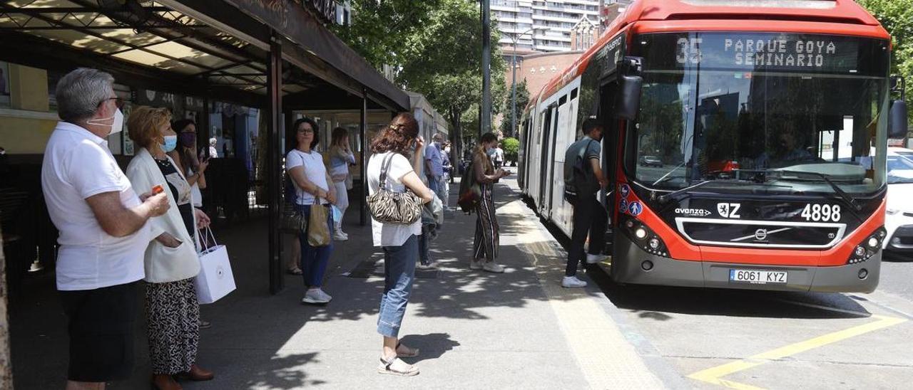 Usuarios del autobús urbano de Zaragoza esperan en una parada del centro de la capital.