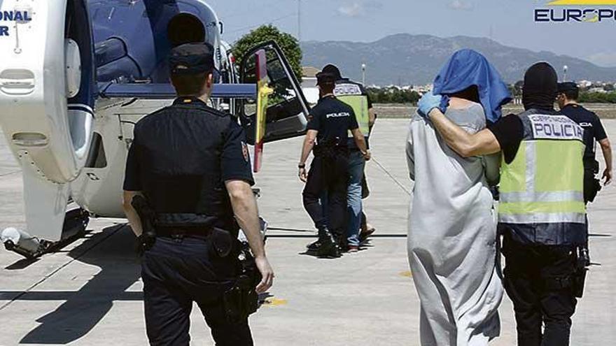 Varios policías trasladan a los sospechosos desde Palma a Madrid tras su detención en junio.