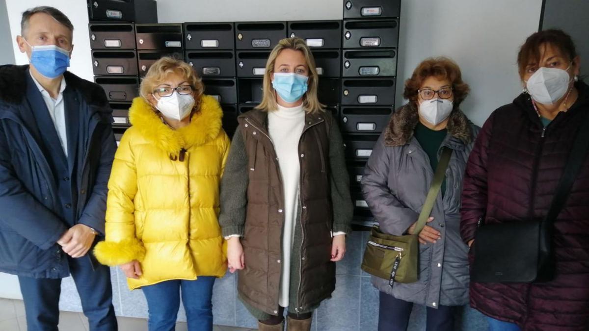 Por la izquierda, Matías Álvarez Feito, Nérida Zambrano, Reyes Fernández Hurlé, Raquel Márquez y Vicki Bello, ayer, en el portal número 9  de la calle Manuel Hevia Carriles, en El Lauredal.