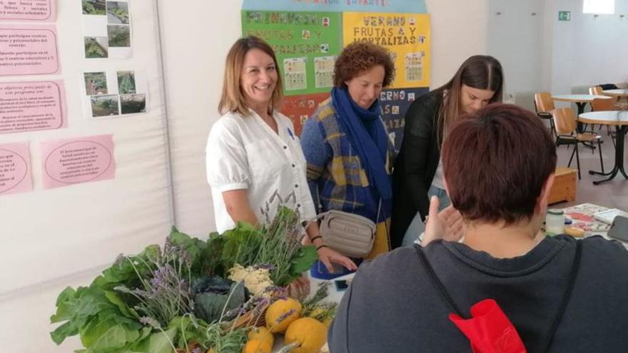 Uno de los expositores de la jornada intergeneracional, durante la visita de la concejala Teresa Iglesias, segunda por la izquierda.